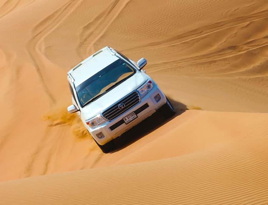 From Doha: Inland Sea Desert Safari with All Activities - Camel riding across the sand